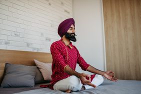 man with turban sitting on bed and meditating 