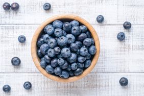 bowl of blueberries on white wooden tabletop