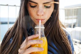 Young woman with low blood sugar drinking orange juice