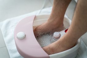close-up of a man's ankles and feet in an electric foot bath