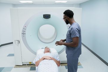Imaging technician talks to person about to have MRI