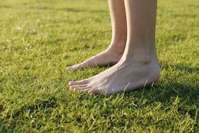 A pair of feet on grass; grounding