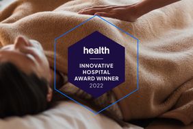 Health Innovative Hospital Award Winner 2022 Badge with a woman lying in the background with a gentle hand on top. 
