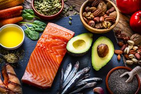 salmon, avocado, sardines, nuts on a table