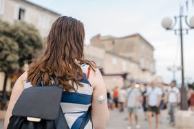 A woman travels in a city while wearing a continuous glucose monitor