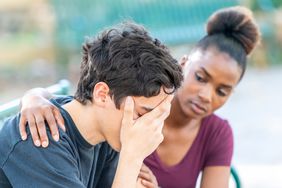 Woman consoles man who appears upset. 