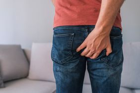 Photo of man hand holding his bottom
