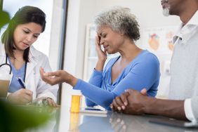 Senior woman in pain talks with docotr 