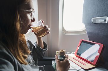 woman drinking ginger ale on plane