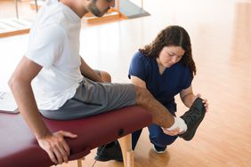 Physical therapist helping person with foot arch pain