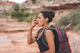 Person using inhaler while on a hike