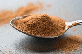 Spoonful of cinnamon on table