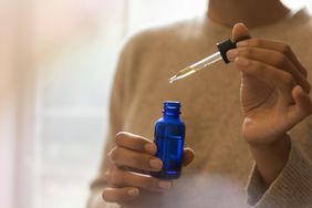 Person using jojoba oil on skin