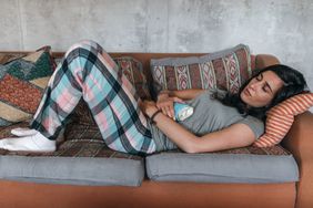 Person lying on couch with stomach pain