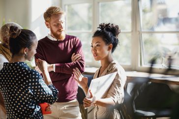 person in the right middle having a conversation, while three other people surround her and listen