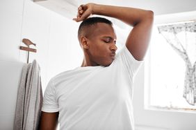 A man sniffs his armpit