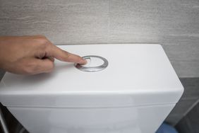 Person flushing toilet