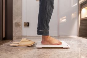 A woman stands on a scale