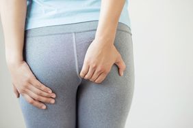 Woman scratching her rear