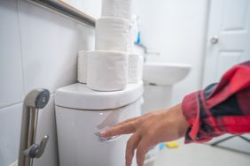 A person flushes the toilet