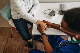 Doctor examining patient's blue fingernails (cyanosis)