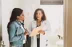 Mid adult female patient listens as doctor reviews treatment plan