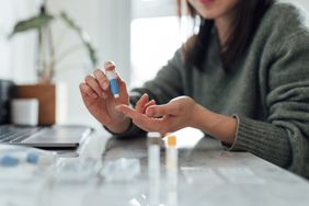 Close-up of person doing a home finger-prick blood test.