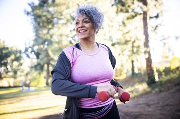 An older woman walks with weights