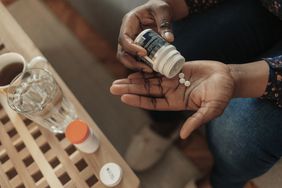 woman taking out pills from bottle