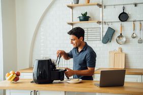 Man kitchen using an air fryer.