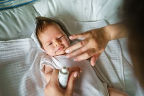 Putting lotion on baby eczema