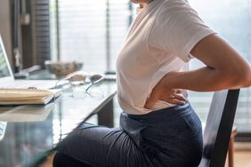 woman at desk suffering from back pain