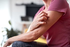 A person itches their upper arm