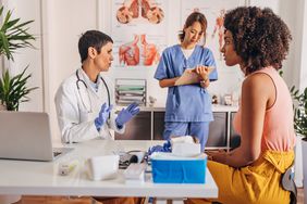 Doctor discussing gut health with a patient, nurse taking notes