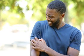 A man itches his arm