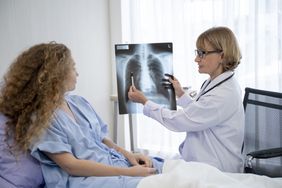 doctor showing person with adenocarcinoma lung cancer an x-ray of their lungs