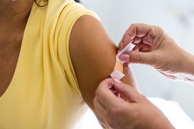 Doctor putting band-aid on patient after giving a vaccine