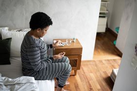 Mature woman take some pills at home