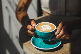 holding cup of coffee