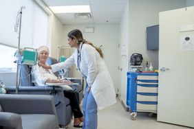 Oncologist checking on person receiving chemotherapy