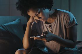 Stressed woman checking phone at night