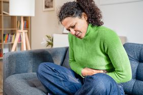 Person grabs their stomach near their appendix in pain. 