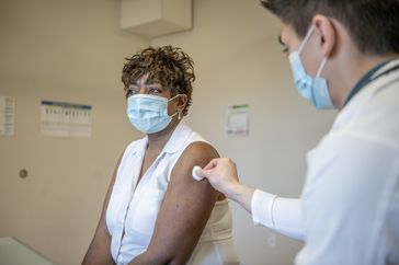 Doctor gives patient a flu shot.