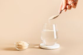 hand adds psyllium fiber to glass of water