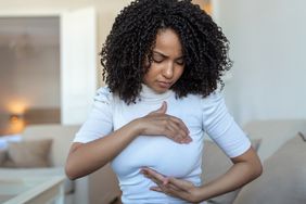 Young woman performing a breast exam