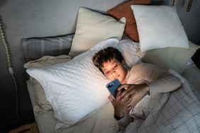 Person on their phone in bed at night.