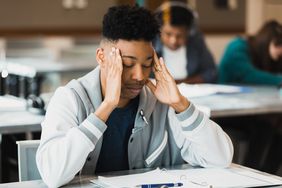 A young man tries to concentrate on his schoolwork 