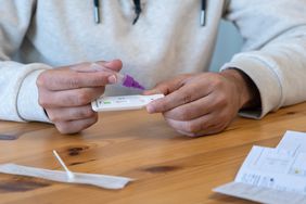 Close-up of man placing the sample into a buffer dropper for seft detection of coronavirus at home. PCR test after come back from crowd and meeting people. Quarantine pandemic.
