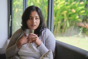 Person drinking water on the couch at the start of a cold