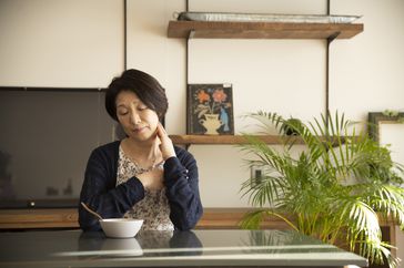 woman looking at bowl of food isn't hungry because of ulcerative colitis pain